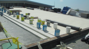 This high-performance roof system was recently installed on a high school north of Chicago. It features two layers of 3-inch 25-psi, double-coated fiberglass-faced polyisocyanurate insulation set in bead-foam adhesive at 4 inches on center, weighted with five 5-gallon pails of adhesive per 4- by 4-foot board to ensure a positive bond into the bead foam until set. PHOTO: Hutchinson Design Group LLC
