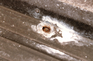 a rusted fastener has caused the surrounding metal to corrode and fail.
