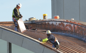 Workers install CopperPlus batten-seam panels over a dome at Lambert-St. Louis International Airport. Stepby- step, the installation of CopperPlus is virtually identical to that of copper.