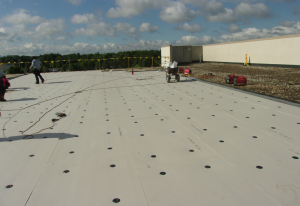 High-density polyisocyanurate is gaining fans with its light weight and ease of handling. In this photo, it is being mechanically fastened in a RhinoBond application. PHOTO: Clark Roofing