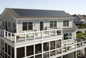 The Westerly, R.I., coastal home features an asphalt laminate shingle and integrated solar shingle roofing system.