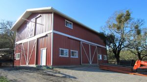 To achieve the traditional barn aesthetic, the wall panels are coated in a Rustic Red color of Fluropon while the metal roof panels are finished in Polar White.
