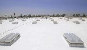 American International Industries restored sections of its roof with a cold-applied system, spray polyurethane expanding foam and smoke-vent skylights. Photo courtesy of SKYCO Skylights. 