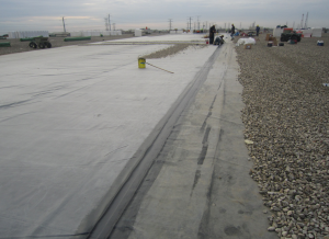 PHOTO 5: The new EPDM membrane over new insulation (left) is in the process of being ballasted. The “night tie-in” is easily accomplished with seam tape and self- adhering cover strips.
