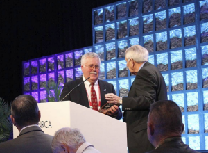 John Gooding accepts the 2016 J.A. Piper Award from 2015 J.A. Piper Award Winner Don McCrory during NRCA’s 129th Annual Convention.